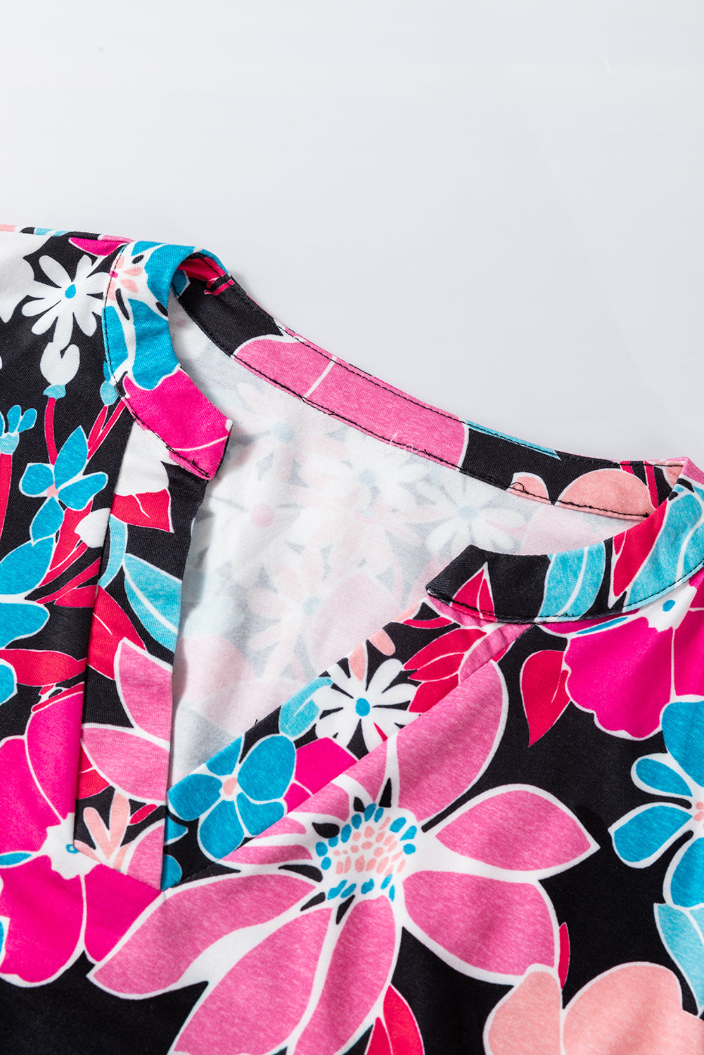 Chemisier rose à fleurs et col en V, manches retroussées