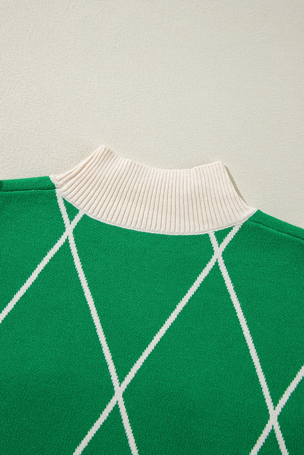 Pull col montant à motif losanges vert foncé avec pompons contrastés