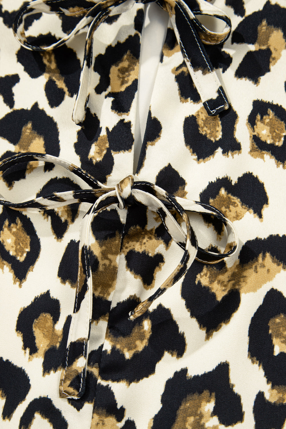 Chemisier péplum à manches bouffantes et nœud papillon sur le devant, motif léopard abricot