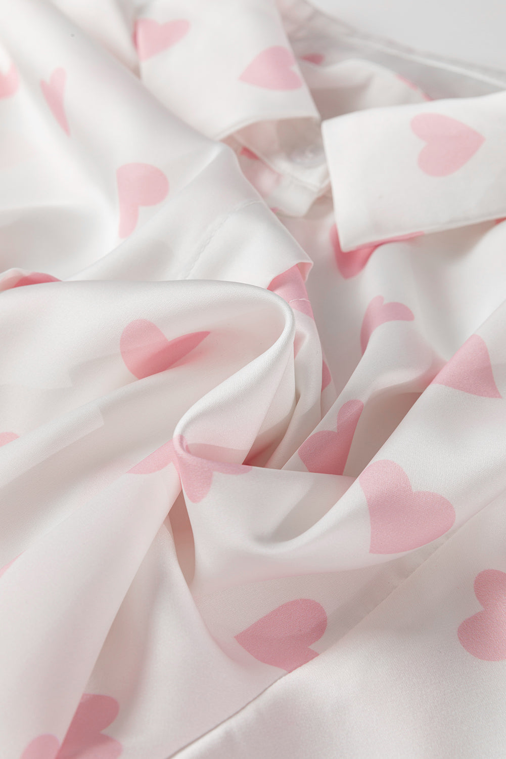 Chemise blanche à manches bouffantes et épaules tombantes avec imprimé cœur