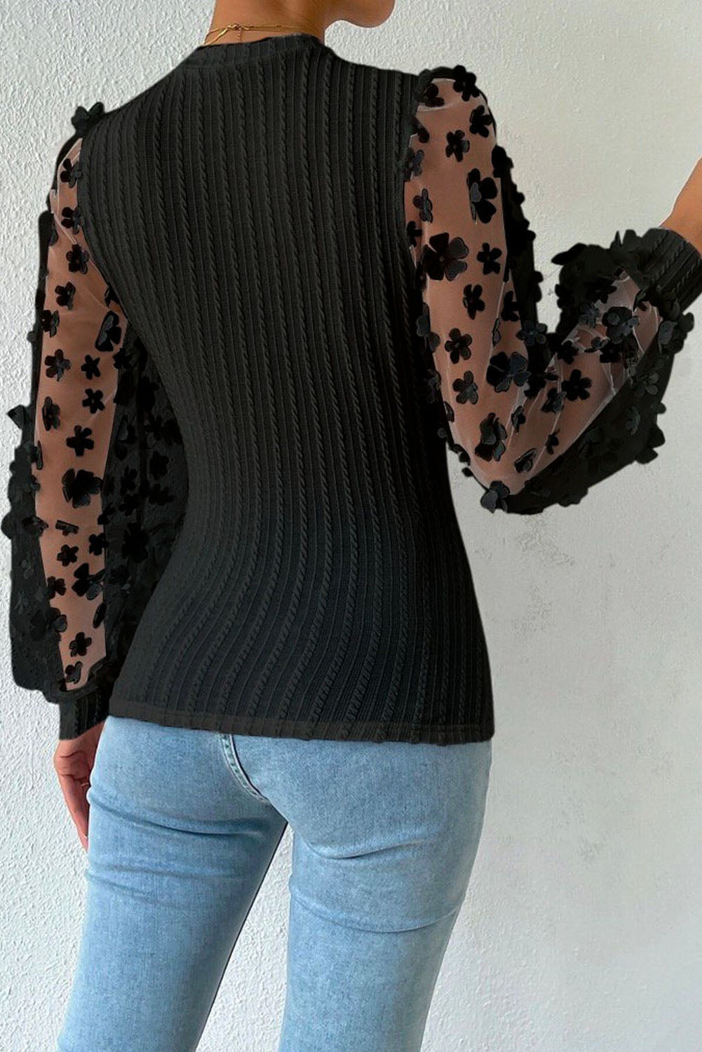 Blusa de punto texturizada con mangas de malla y apliques florales 