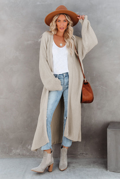Cardigan beige en maille ouverte sur le devant et fendu sur le côté 