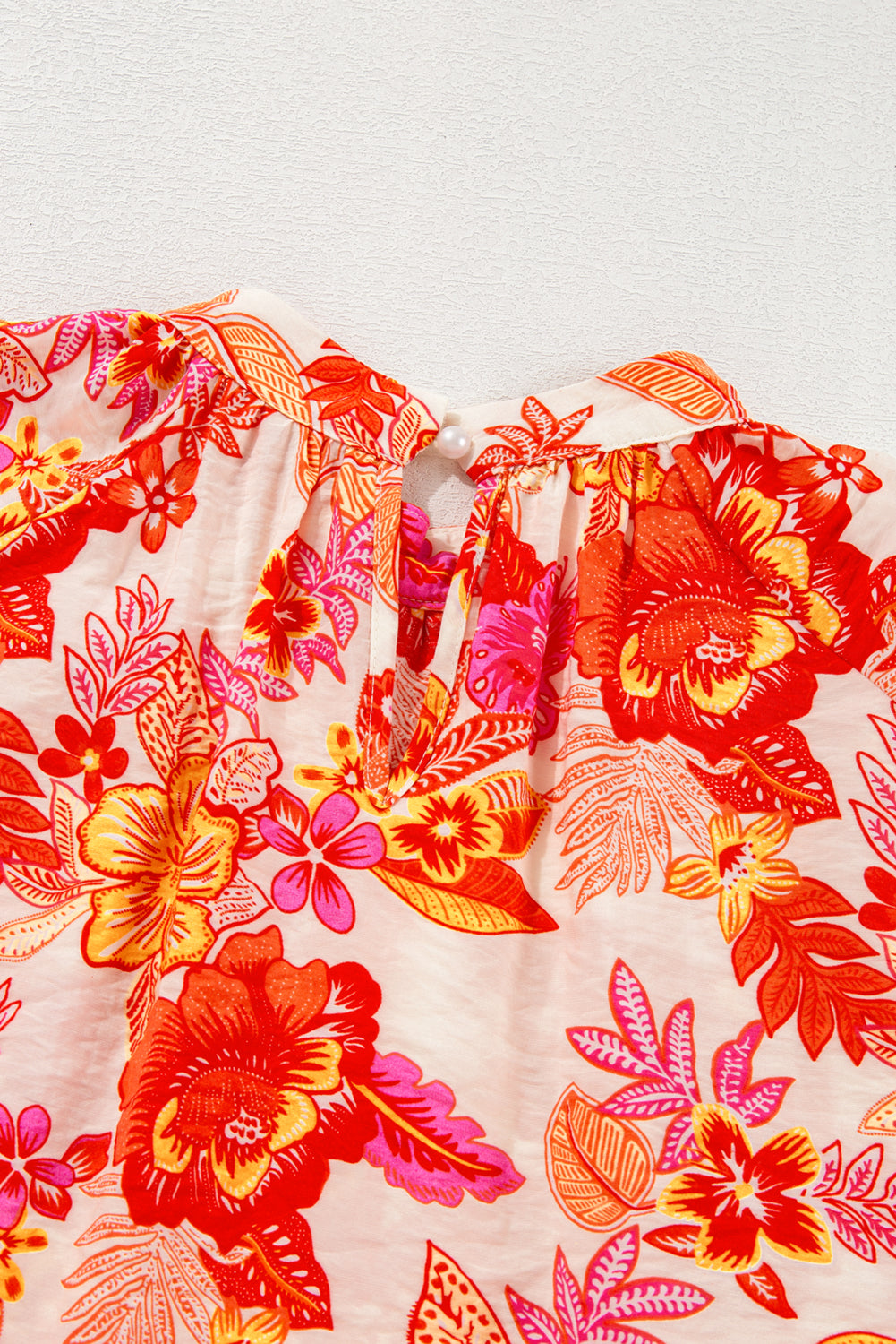 Chemisier orange à imprimé floral, boutons nacrés, manches longues bouffantes et trou de serrure