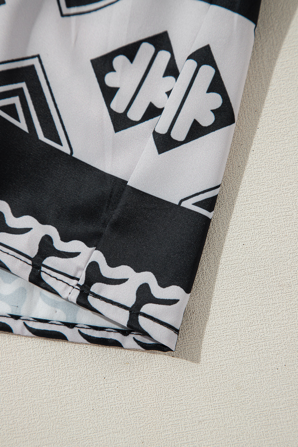 Robe noire à volants et col en V à imprimé géométrique