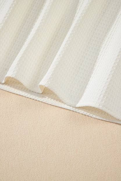 Chemisier blanc uni en tricot gaufré à volants