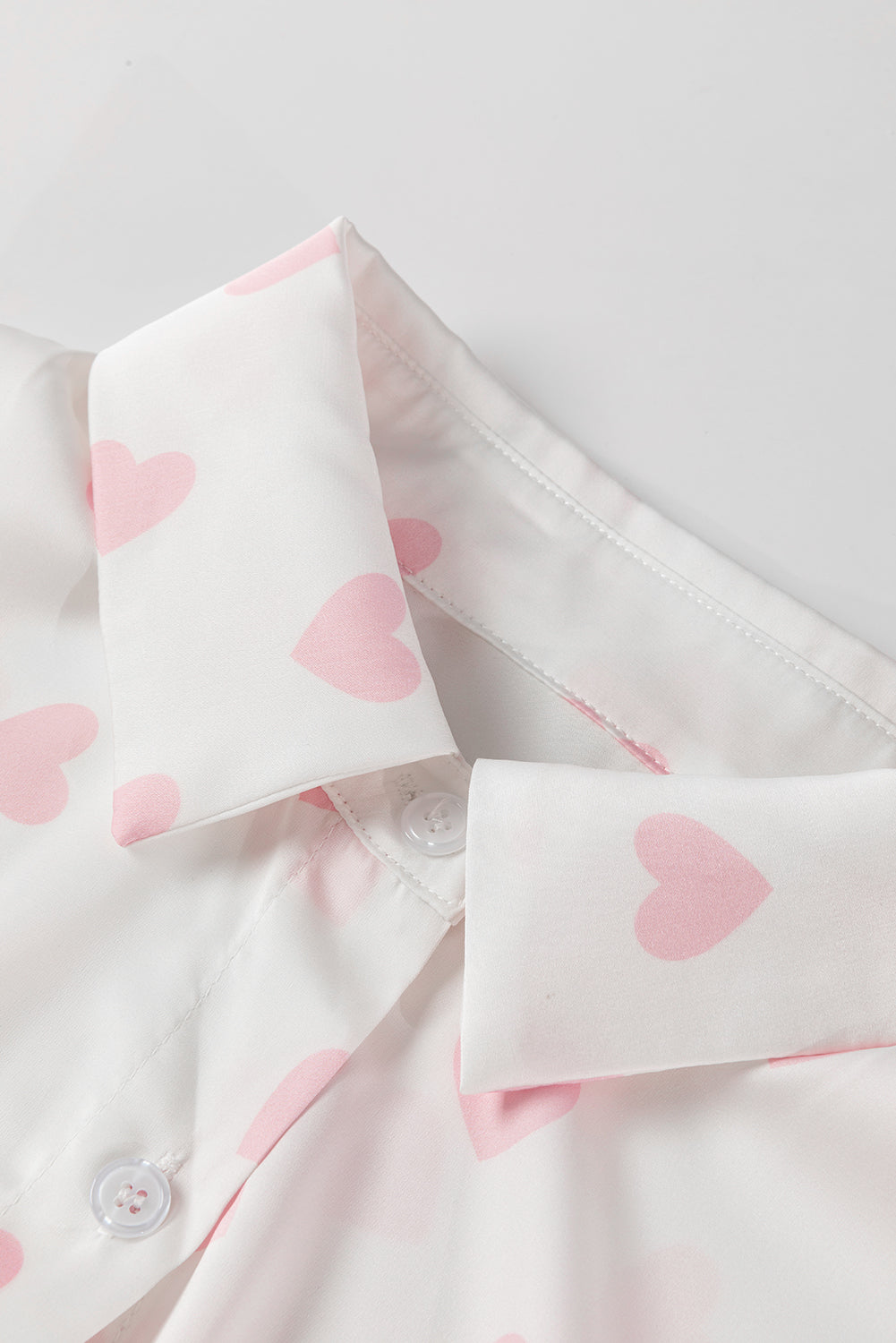 Chemise blanche à manches bouffantes et épaules tombantes avec imprimé cœur