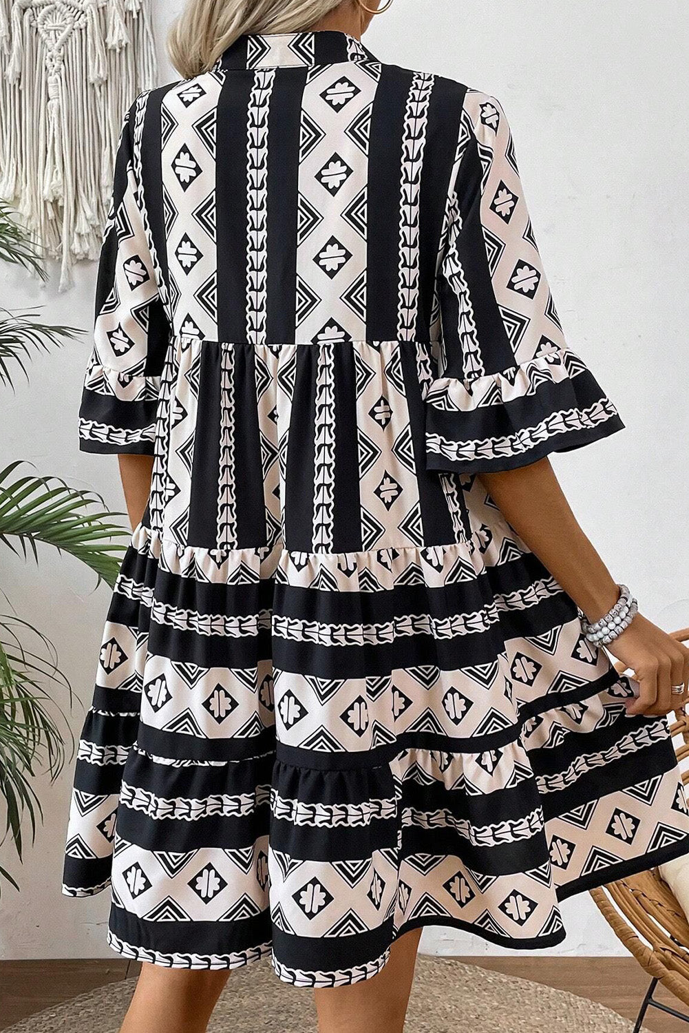 Robe noire à volants et col en V à imprimé géométrique