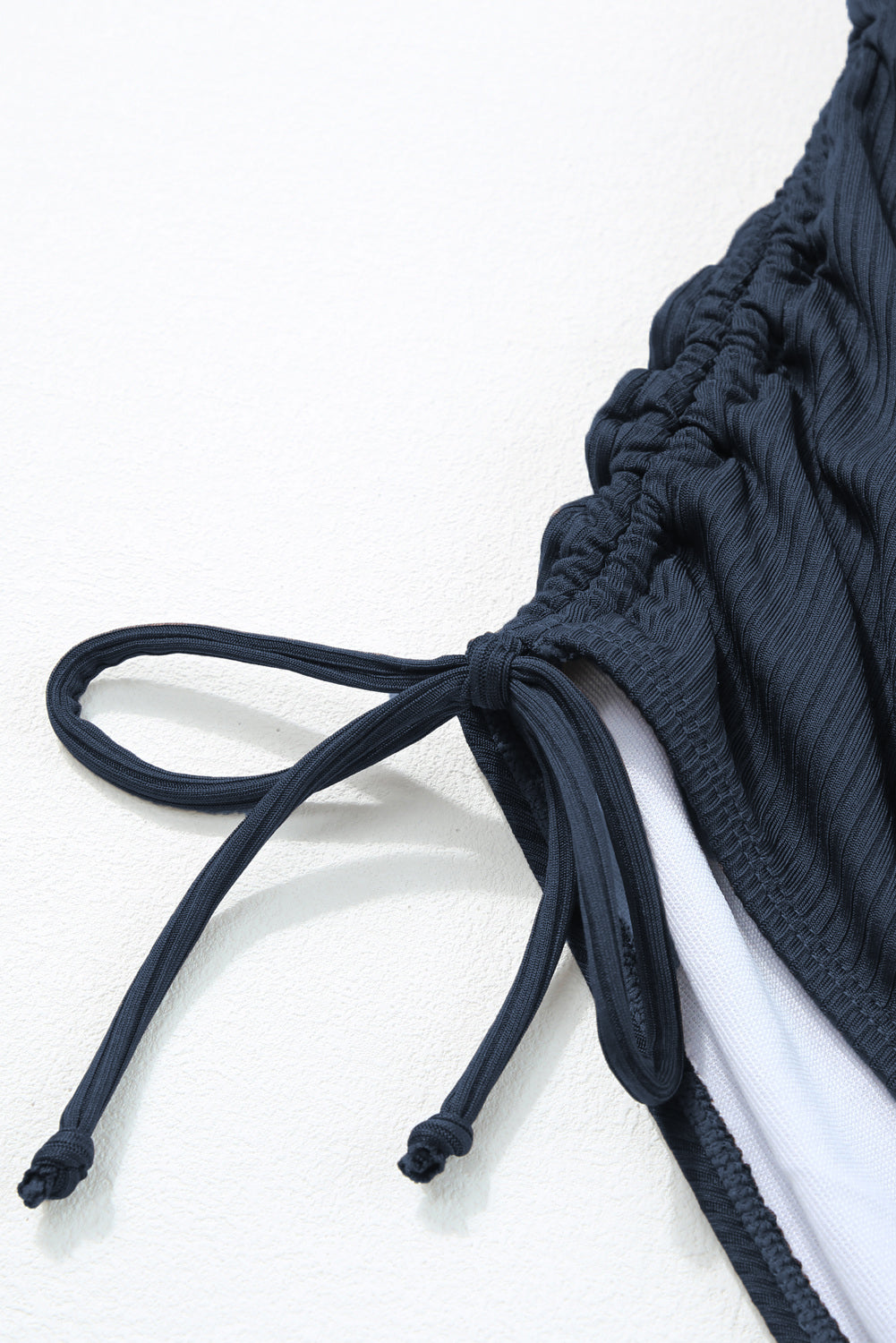 Maillot de bain une pièce bleu marine côtelé avec cordon de serrage et découpes sur les côtés