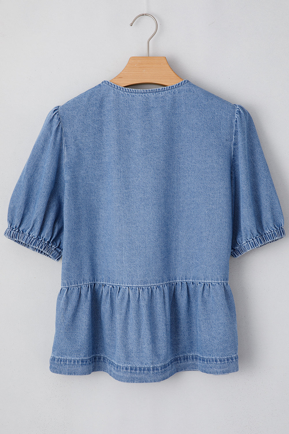 Chemise en jean péplum bleu crépuscule à manches bouffantes et nouée sur le devant