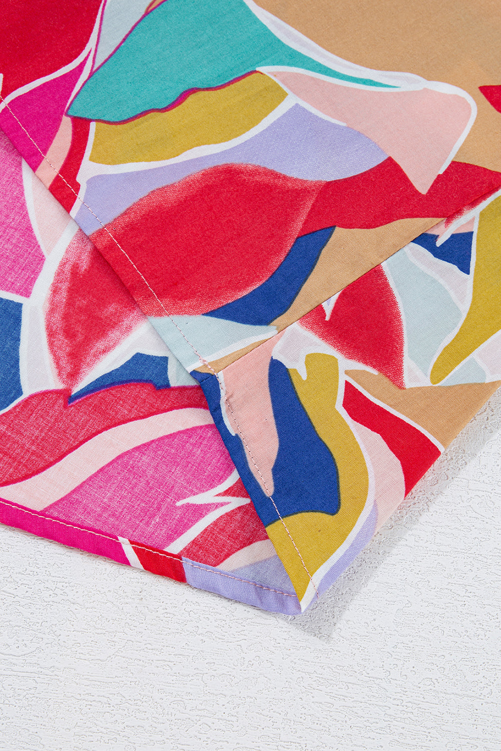 Chemisier rose à imprimé abstrait, manches volantées, col en V fendu et noué