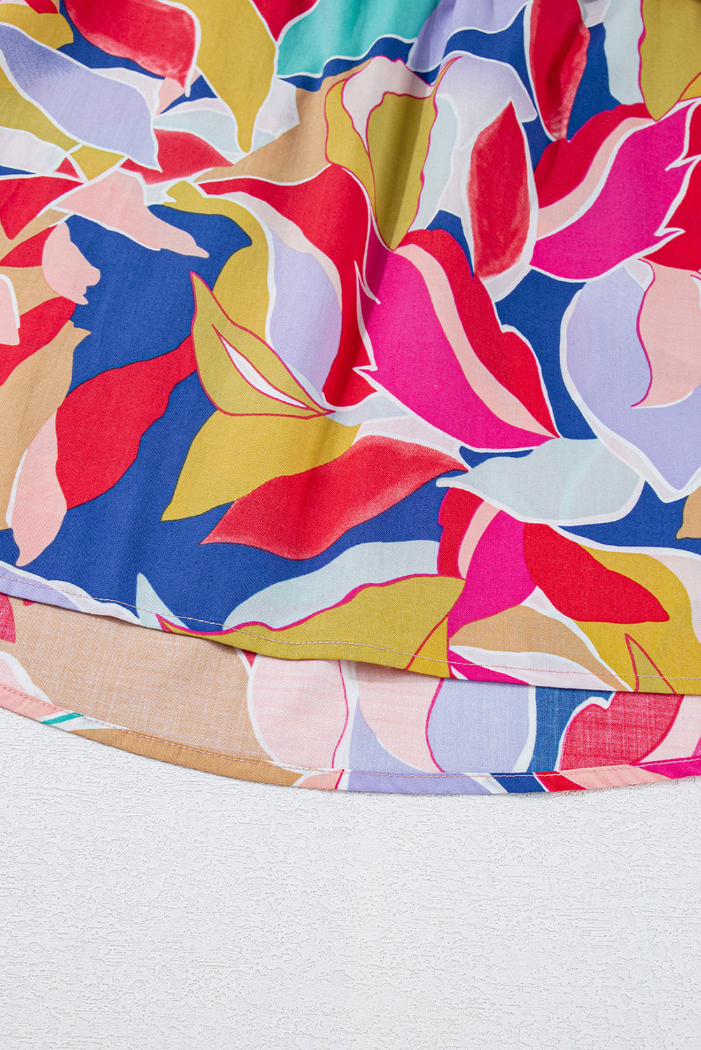 Chemisier rose à imprimé abstrait, manches volantées, col en V fendu et noué