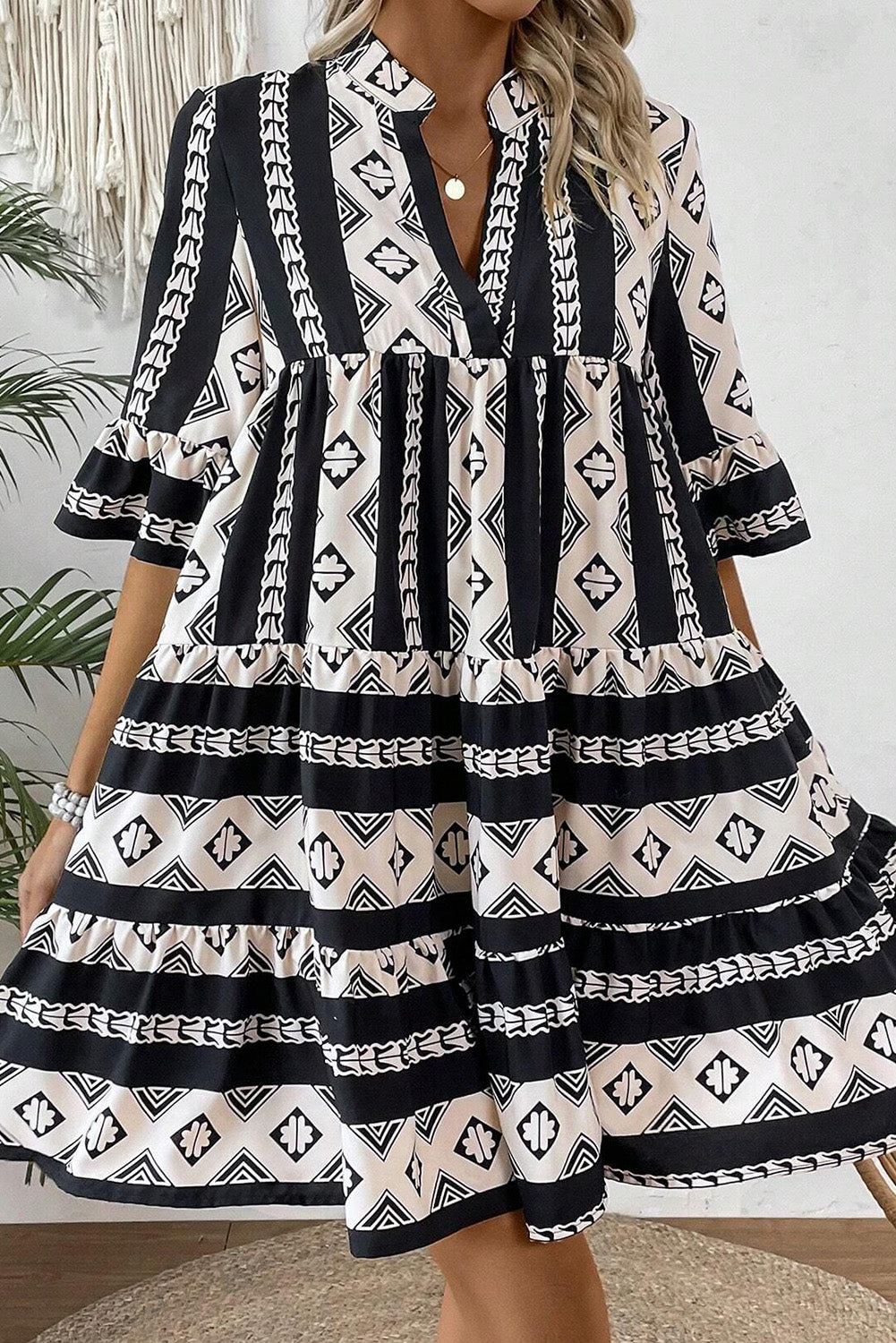 Robe noire à volants et col en V à imprimé géométrique