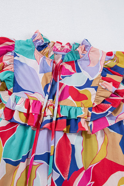Chemisier rose à imprimé abstrait, manches volantées, col en V fendu et noué