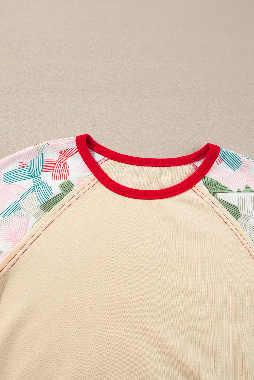 Haut beige à manches raglan et bordures colorblock, imprimé patchwork et nœud papillon