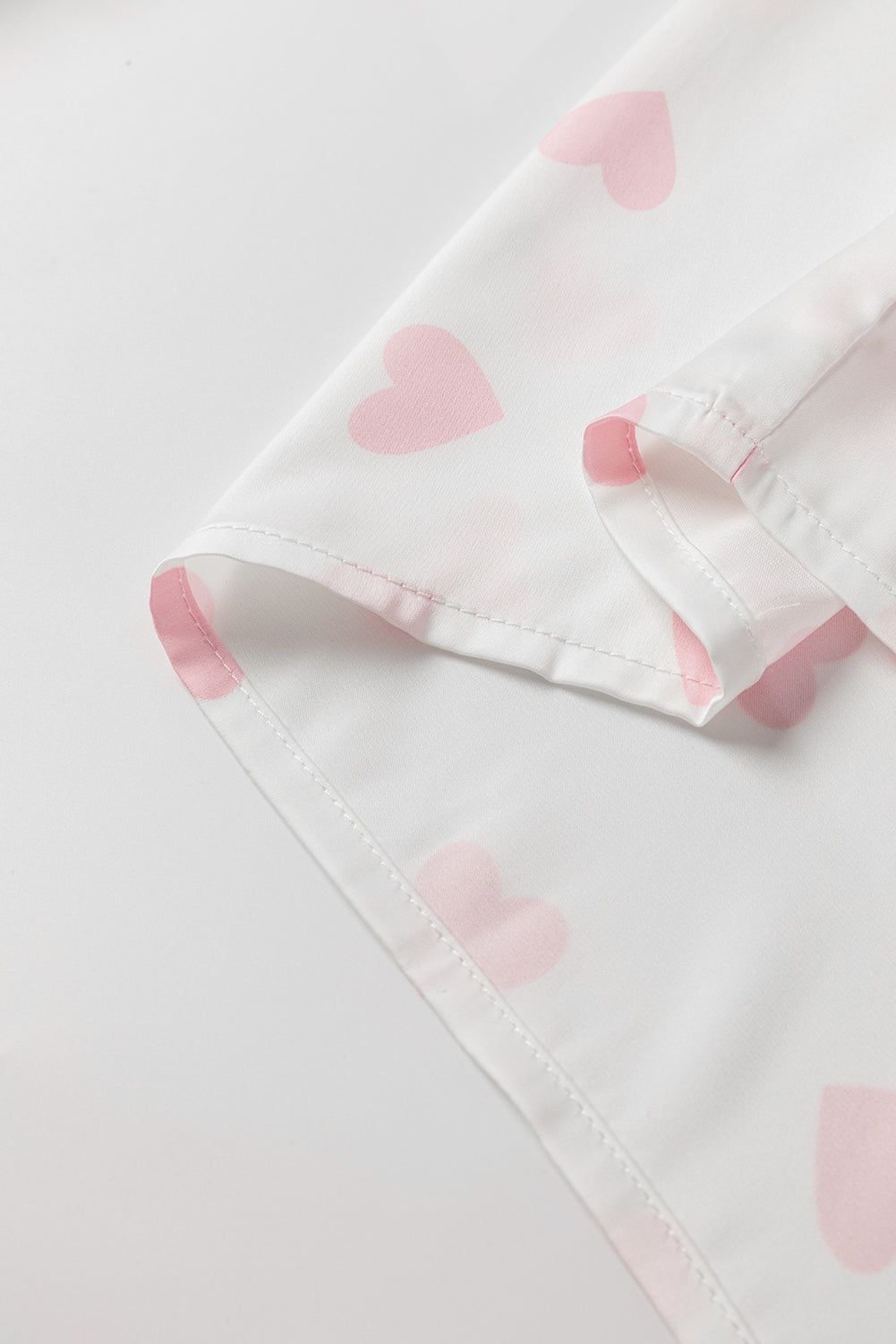 Chemise blanche à manches bouffantes et épaules tombantes avec imprimé cœur