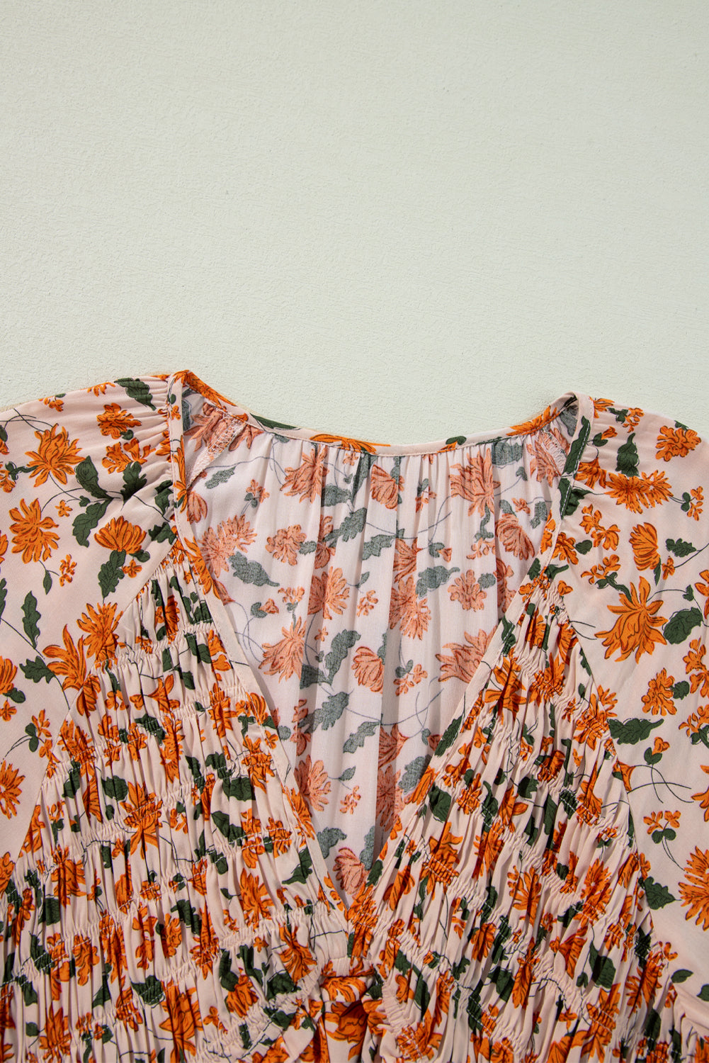 Robe babydoll beige à fleurs, décolleté en V profond, buste froncé, manches bouffantes