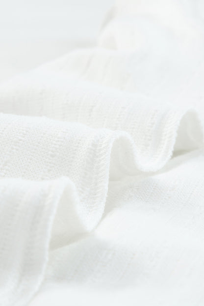 Blusa de punto texturizada con mangas de malla y apliques florales 