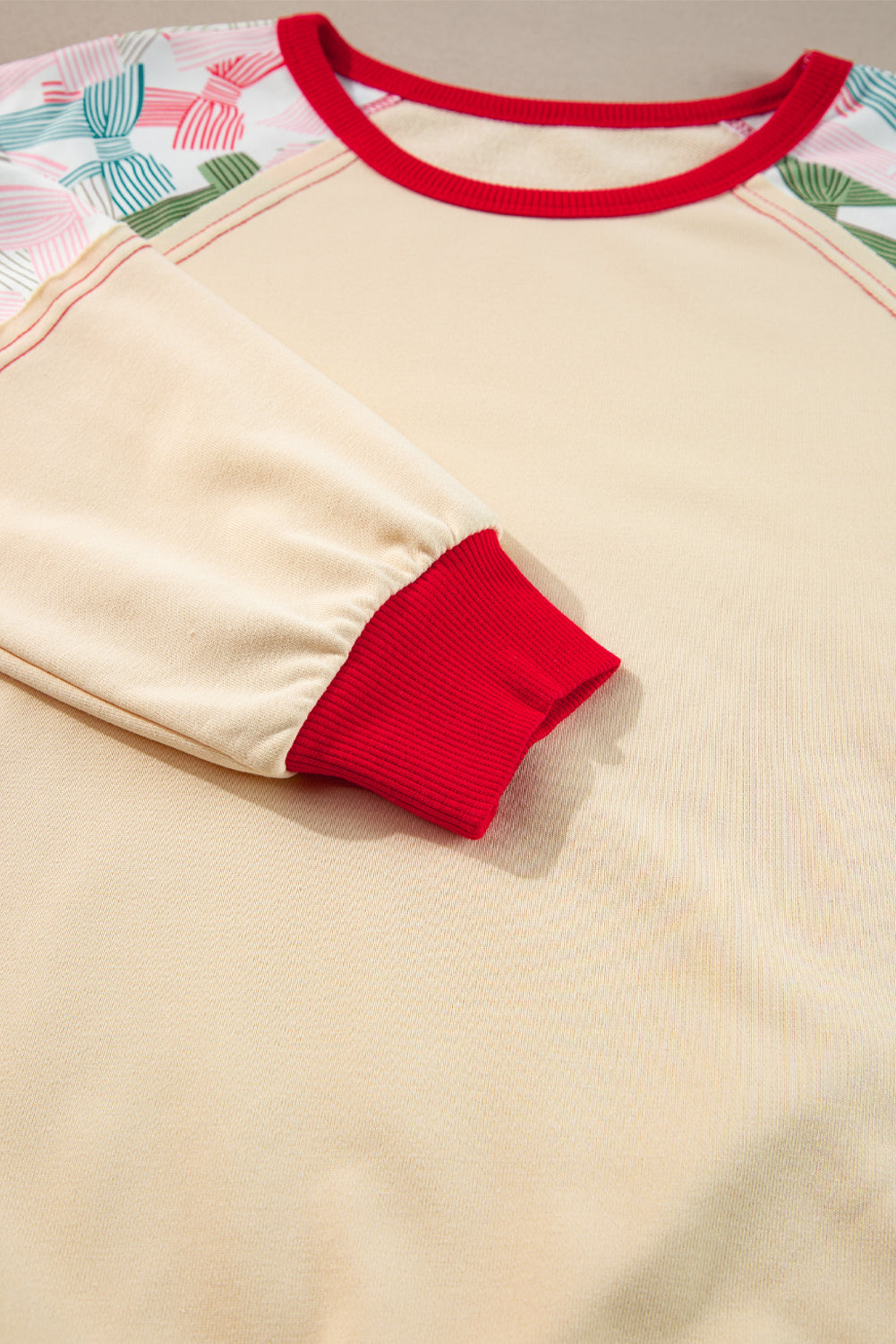 Haut beige à manches raglan et bordures colorblock, imprimé patchwork et nœud papillon