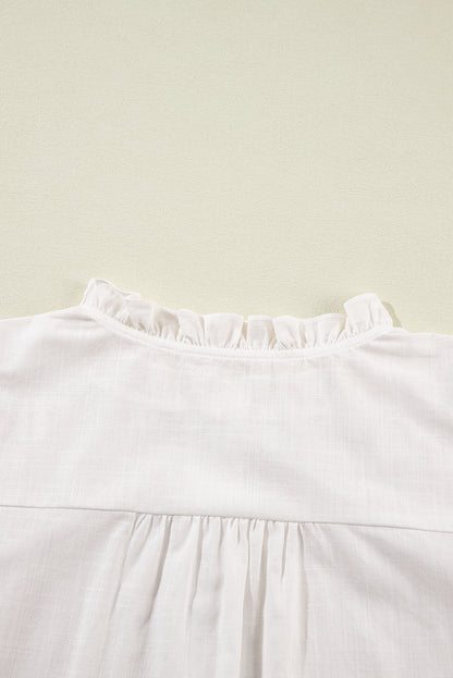 Chemise blanche à manches bouffantes brodées de fleurs