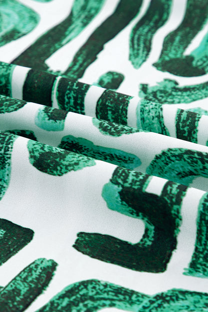 Haut imprimé vert noirâtre à manches bouffantes et col à volants