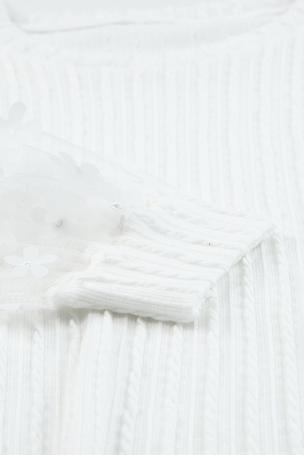 Blusa de punto texturizada con mangas de malla y apliques florales 