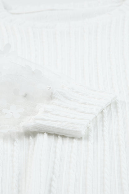 Blusa de punto texturizada con mangas de malla y apliques florales 