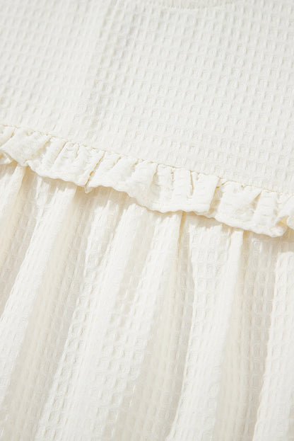 Chemisier blanc uni en tricot gaufré à volants