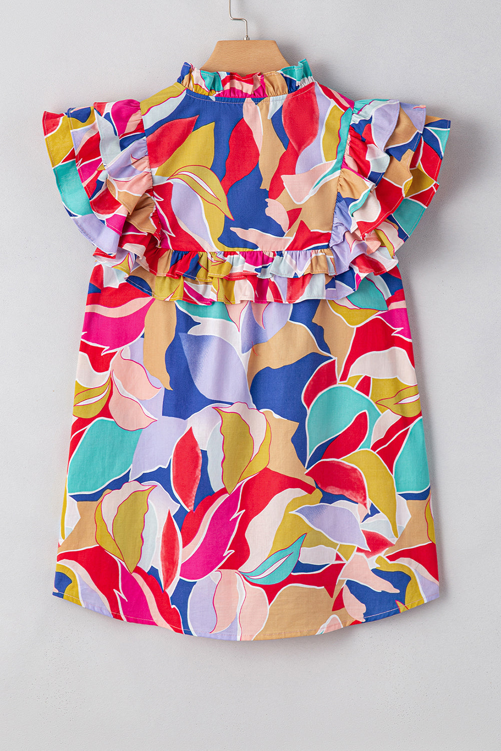Chemisier rose à imprimé abstrait, manches volantées, col en V fendu et noué