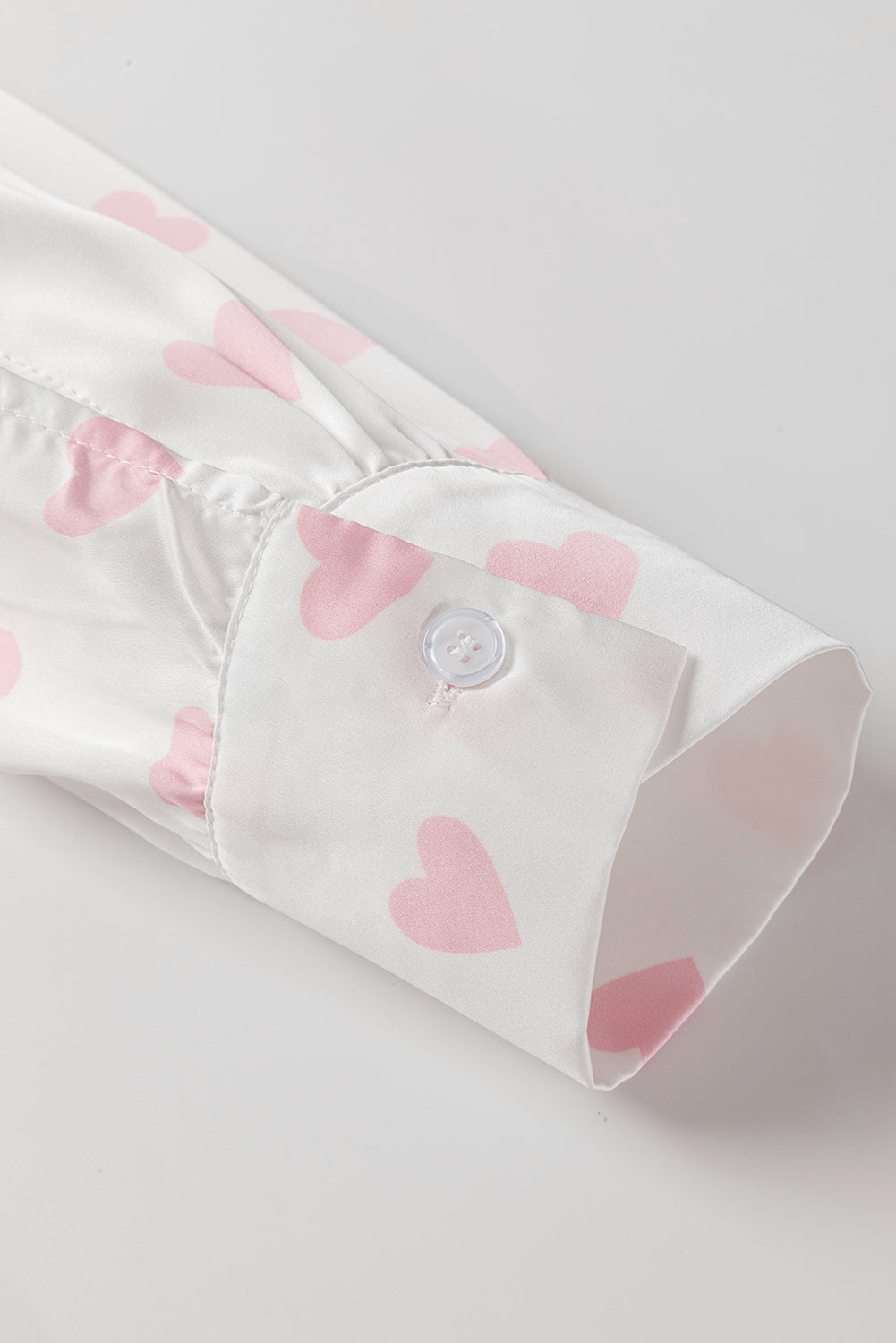 Chemise blanche à manches bouffantes et épaules tombantes avec imprimé cœur