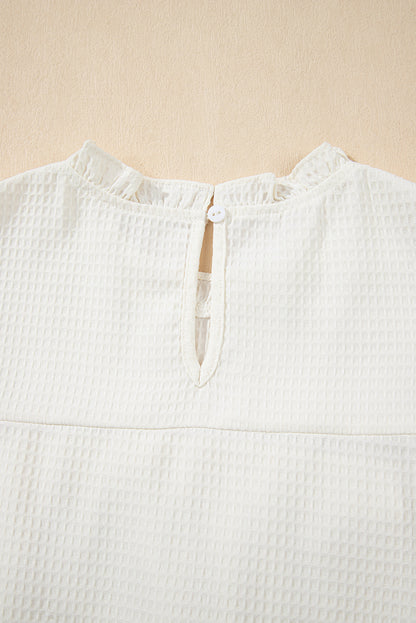Chemisier blanc uni en tricot gaufré à volants