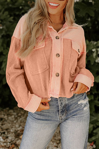 Veste courte en tricot gaufré texturé orange avec poches poitrine 