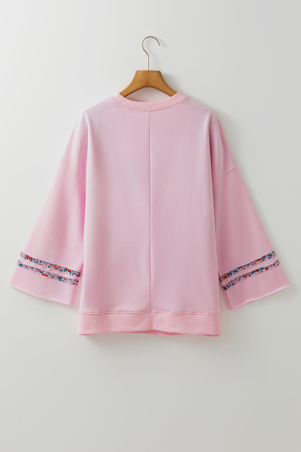 Haut décontracté rose clair à manches larges et épaules tombantes, motif floral et symbole de la paix