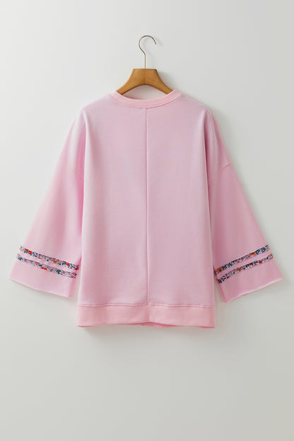 Haut décontracté rose clair à manches larges et épaules tombantes, motif floral et symbole de la paix