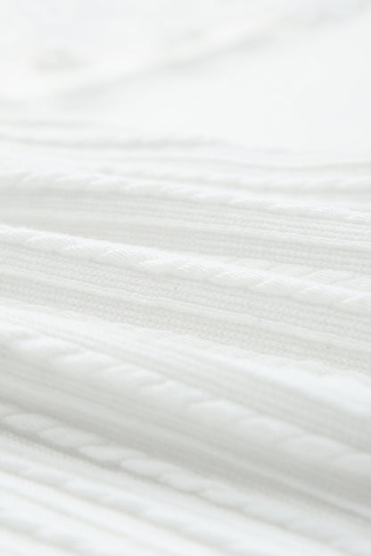 Blusa de punto texturizada con mangas de malla y apliques florales 