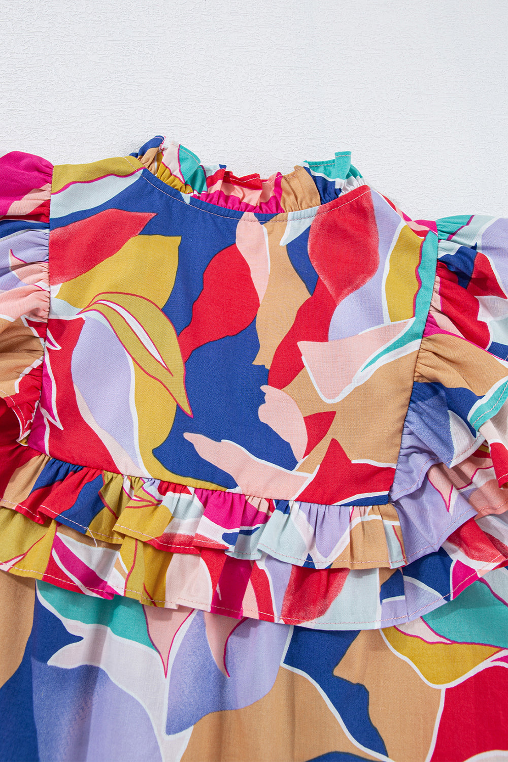 Chemisier rose à imprimé abstrait, manches volantées, col en V fendu et noué