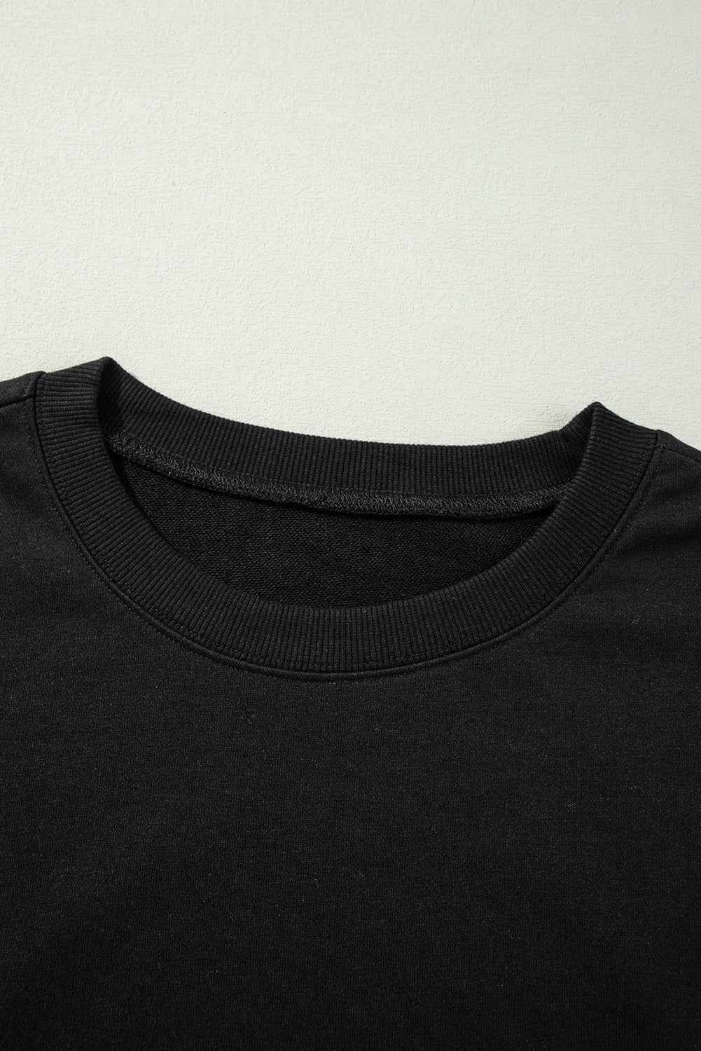 Sweat-shirt noir à col rond et épaules tombantes avec coutures apparentes et fentes