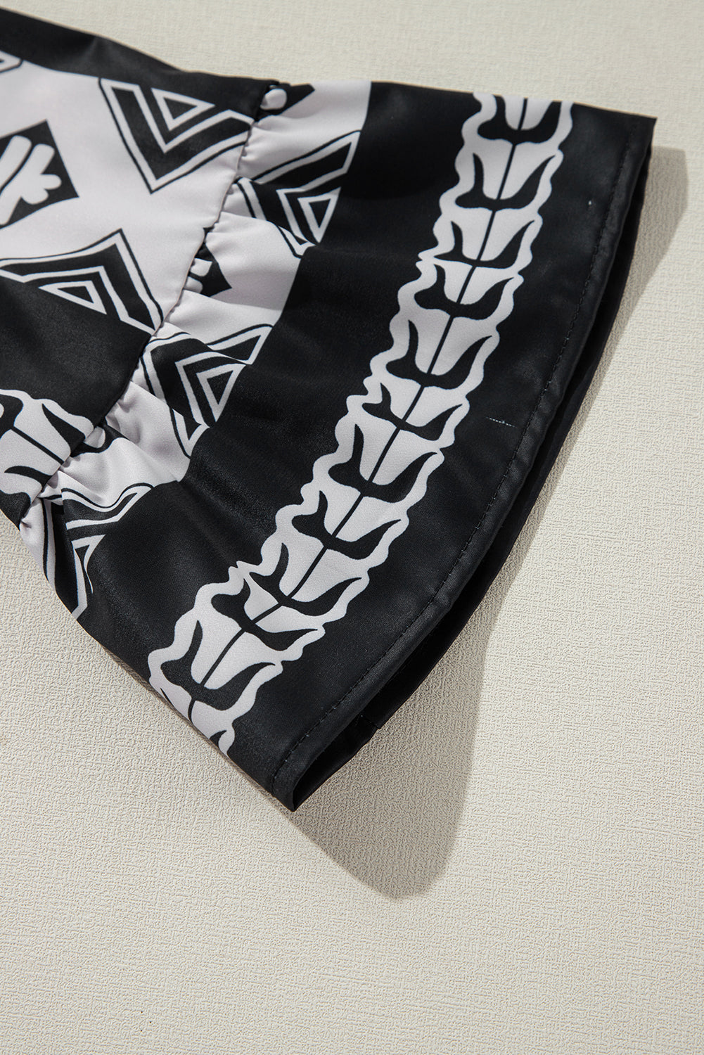 Robe noire à volants et col en V à imprimé géométrique