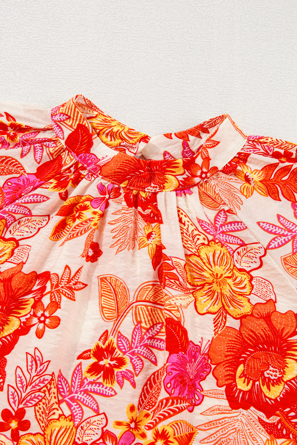 Chemisier orange à imprimé floral, boutons nacrés, manches longues bouffantes et trou de serrure