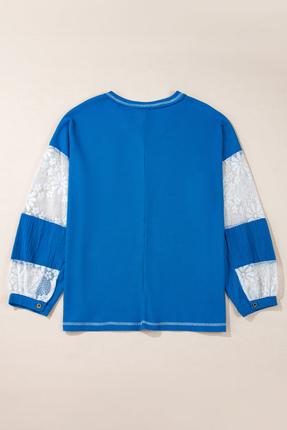 Chemisier en maille côtelée bleu ciel à manches patchwork florales et col en V