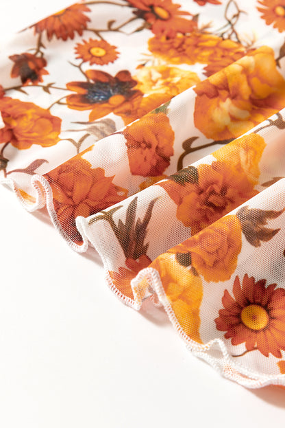 Chemisier orange à imprimé floral, manches cloche, col montant, bordure festonnée